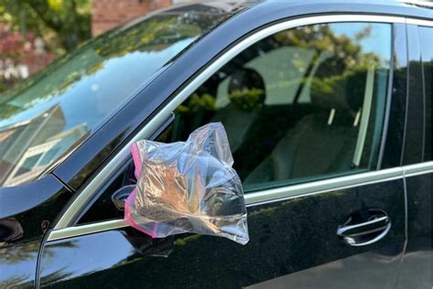 people putting bags over car mirrors.